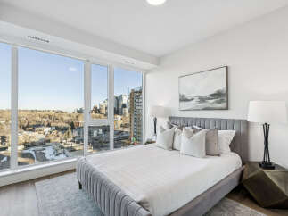 Experience luxury living in this stunning bedroom with breathtaking city views.