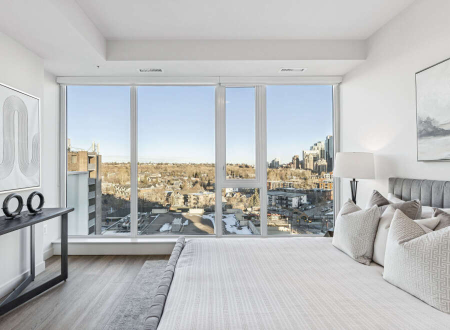Experience luxury living in this stunning bedroom with breathtaking city views.