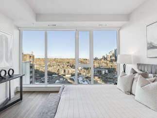 Experience luxury living in this stunning bedroom with breathtaking city views.