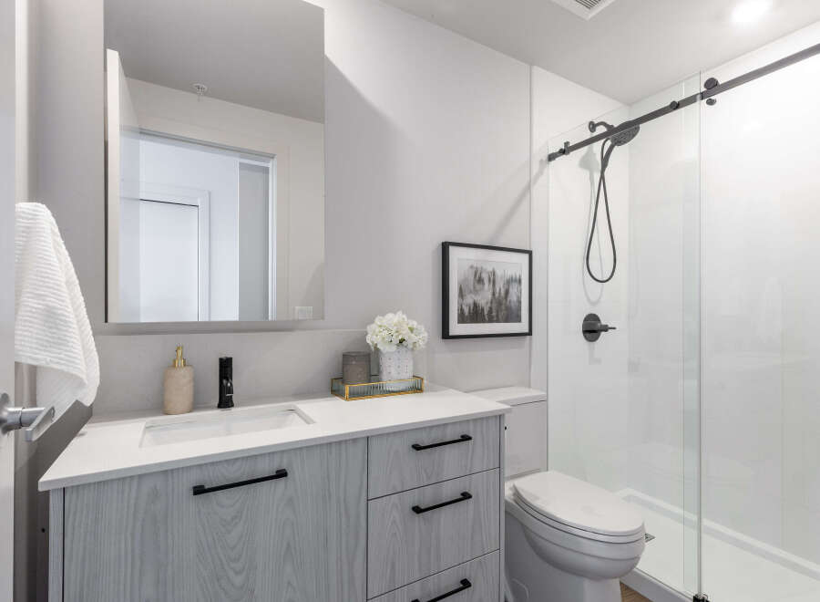 Step into a modern bathroom oasis! This stunning space features a sleek vanity with ample storage, complemented by a stylish black faucet and hardware.