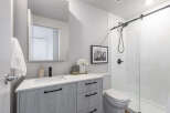 Step into a modern bathroom oasis! This stunning space features a sleek vanity with ample storage, complemented by a stylish black faucet and hardware.