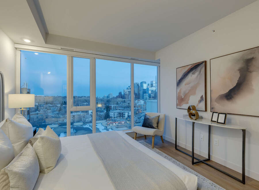 Experience luxury living in this stunning bedroom with breathtaking city views.