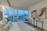 Experience luxury living in this stunning bedroom with breathtaking city views.