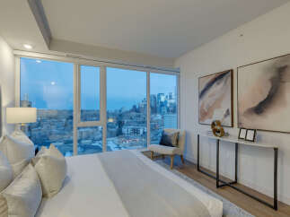 Experience luxury living in this stunning bedroom with breathtaking city views.