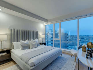 Experience luxury in this stunning bedroom with breathtaking city views.