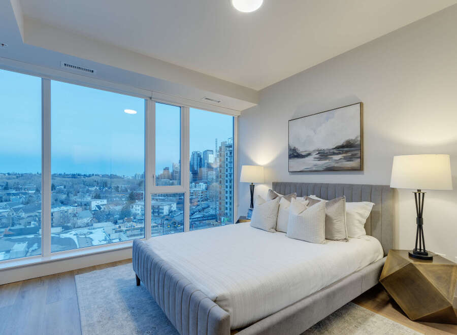 Experience luxury living in this stunning bedroom with breathtaking city views.