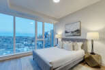 Experience luxury living in this stunning bedroom with breathtaking city views.