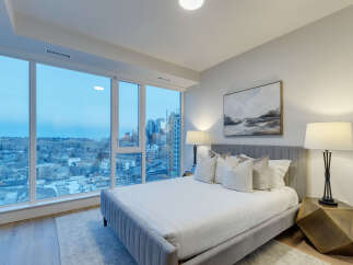 Experience luxury living in this stunning bedroom with breathtaking city views.