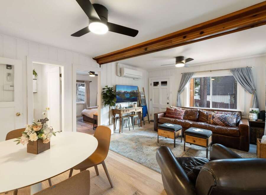 Step into this inviting living space, featuring a cozy leather sofa and stylish ottomans.