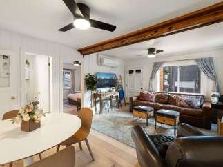 Step into this inviting living space, featuring a cozy leather sofa and stylish ottomans.