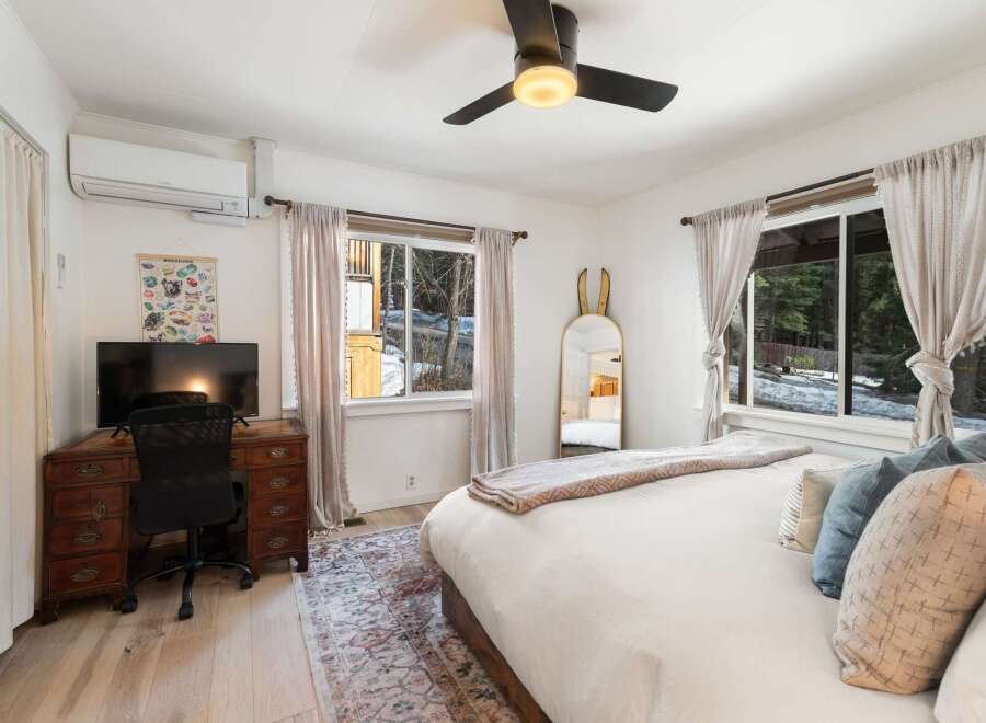 This cozy bedroom features a comfortable bed with plush pillows and a stylish rug.