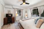 This cozy bedroom features a comfortable bed with plush pillows and a stylish rug.