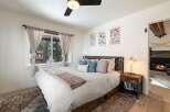 This cozy bedroom features a comfortable bed with soft bedding and decorative pillows, perfect for a relaxing retreat.