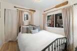 This charming bedroom features a cozy bed with plush pillows, perfect for a relaxing retreat.