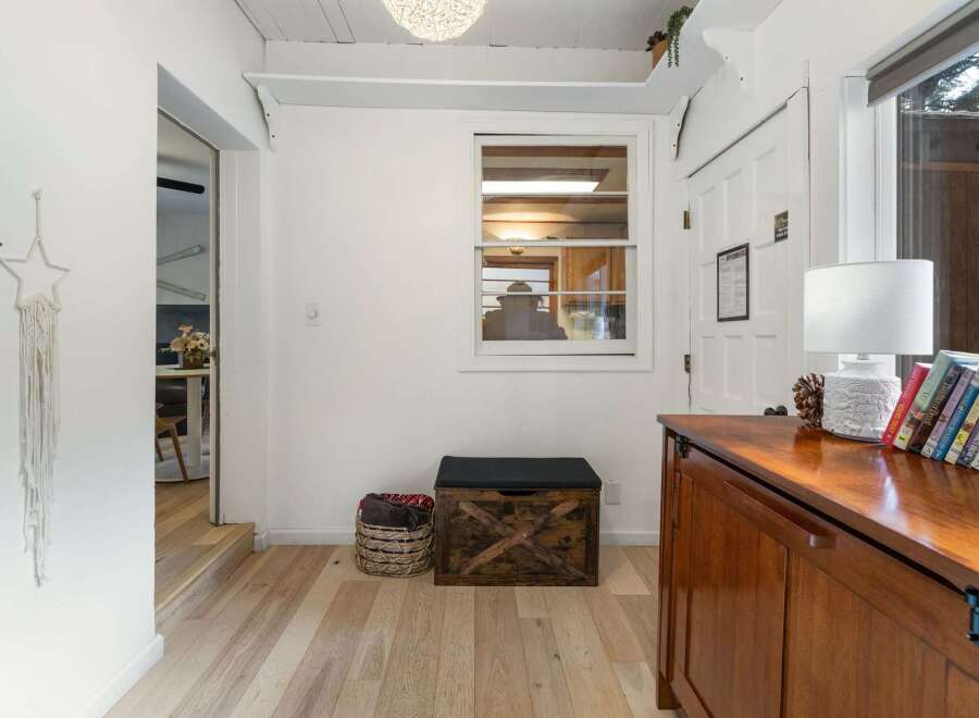 Step into this inviting entryway, featuring beautiful hardwood floors and a stylish wooden chest.