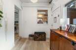 Step into this inviting entryway, featuring beautiful hardwood floors and a stylish wooden chest.