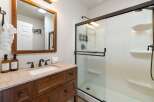 Step into a beautifully designed bathroom featuring a stylish vanity with a granite countertop and a large mirror.