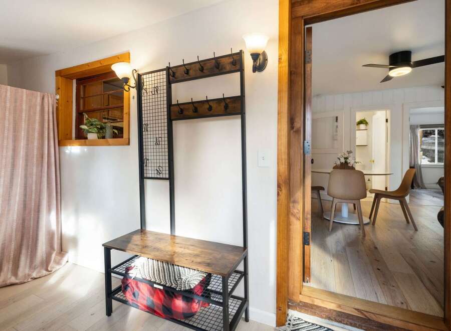 Step into this inviting entryway, showcasing a stylish coat rack with a bench, perfect for organizing your belongings.