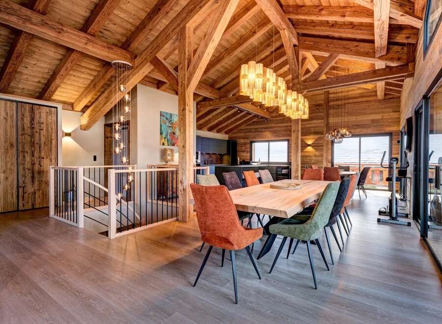Experience luxury living in this stunning chalet, featuring a spacious open-plan design with exposed wooden beams and a modern kitchen.