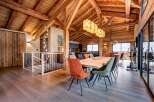 Experience luxury living in this stunning chalet, featuring a spacious open-plan design with exposed wooden beams and a modern kitchen.