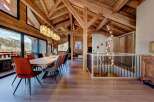 Experience luxury living in this stunning chalet, featuring a spacious dining area with a large wooden table and comfortable seating.