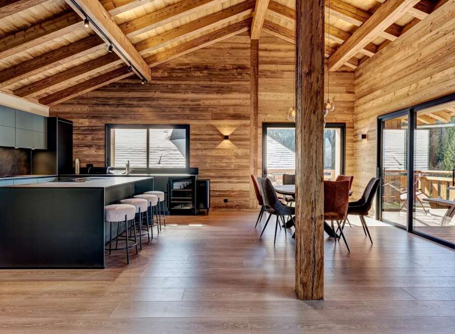This stunning property boasts a modern kitchen with sleek black cabinetry and a large island, perfect for entertaining.