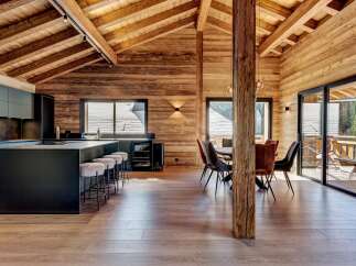 This stunning property boasts a modern kitchen with sleek black cabinetry and a large island, perfect for entertaining.