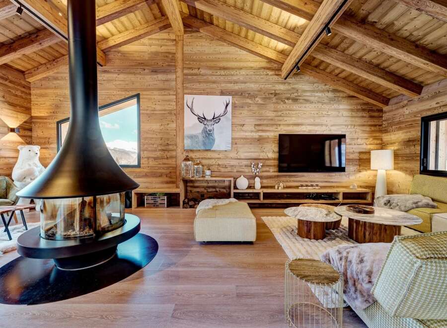 Experience luxury living in this stunning chalet, featuring a striking fireplace and a cozy living area.