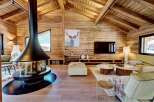 Experience luxury living in this stunning chalet, featuring a striking fireplace and a cozy living area.