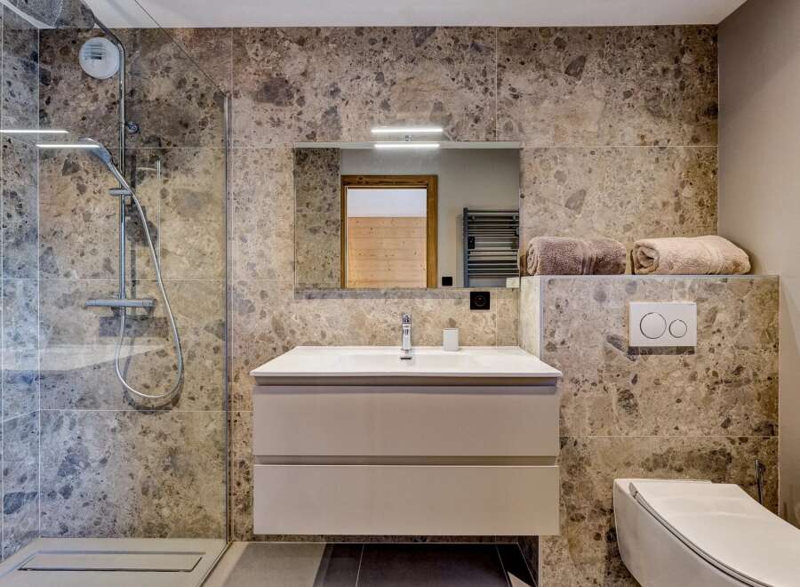 This stunning bathroom features a modern design with a sleek vanity and a spacious shower.