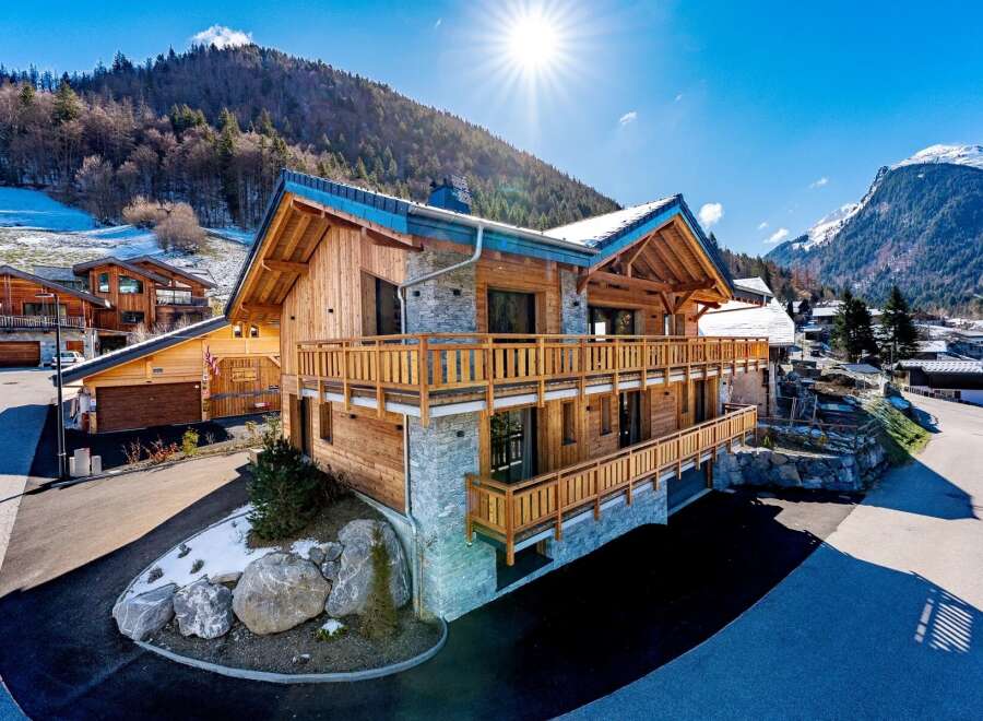 This stunning chalet boasts a beautiful wooden exterior and a stone facade, creating a perfect blend of rustic charm and modern elegance.