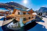 This stunning chalet boasts a beautiful wooden exterior and a stone facade, creating a perfect blend of rustic charm and modern elegance.