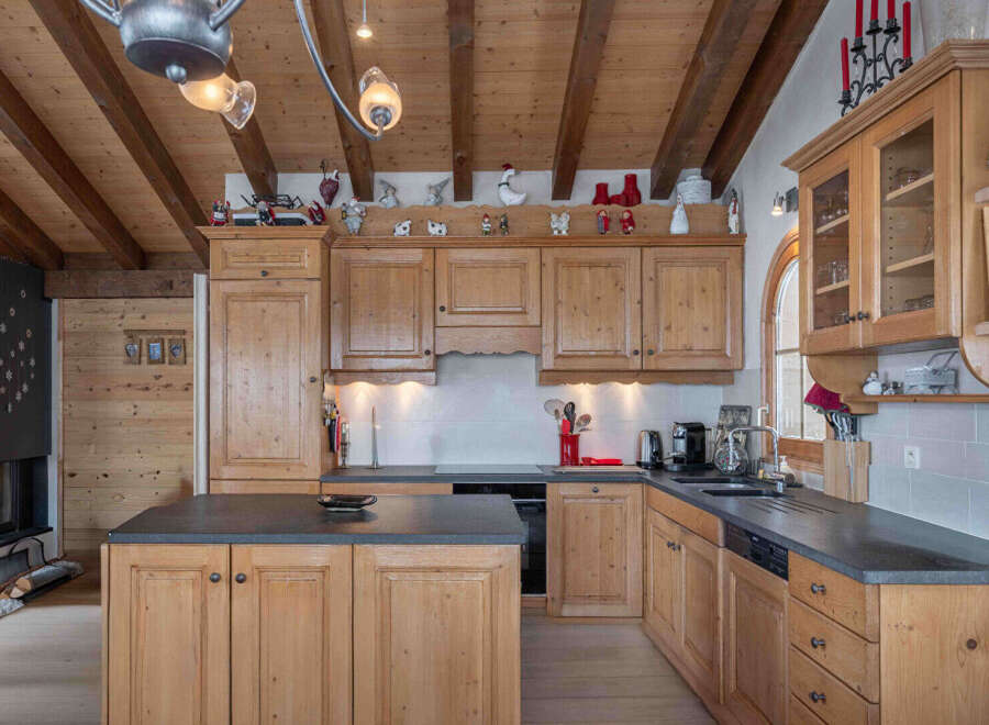 This charming kitchen boasts a warm, inviting atmosphere with its wooden cabinetry and exposed beams.