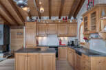 This charming kitchen boasts a warm, inviting atmosphere with its wooden cabinetry and exposed beams.