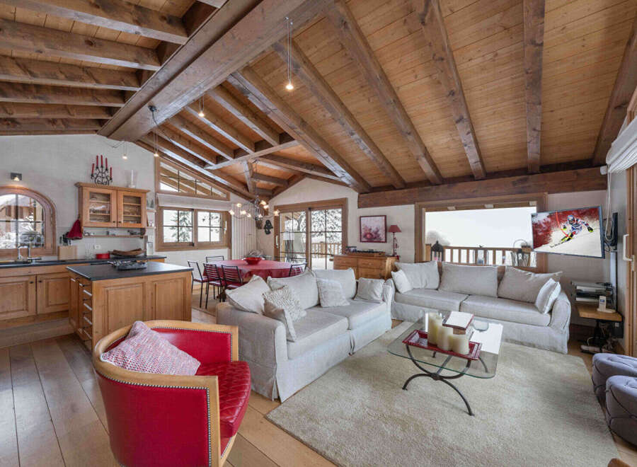 This stunning chalet boasts a warm and inviting interior with exposed wooden beams and a cozy fireplace.