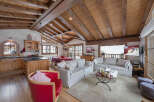 This stunning chalet boasts a warm and inviting interior with exposed wooden beams and a cozy fireplace.