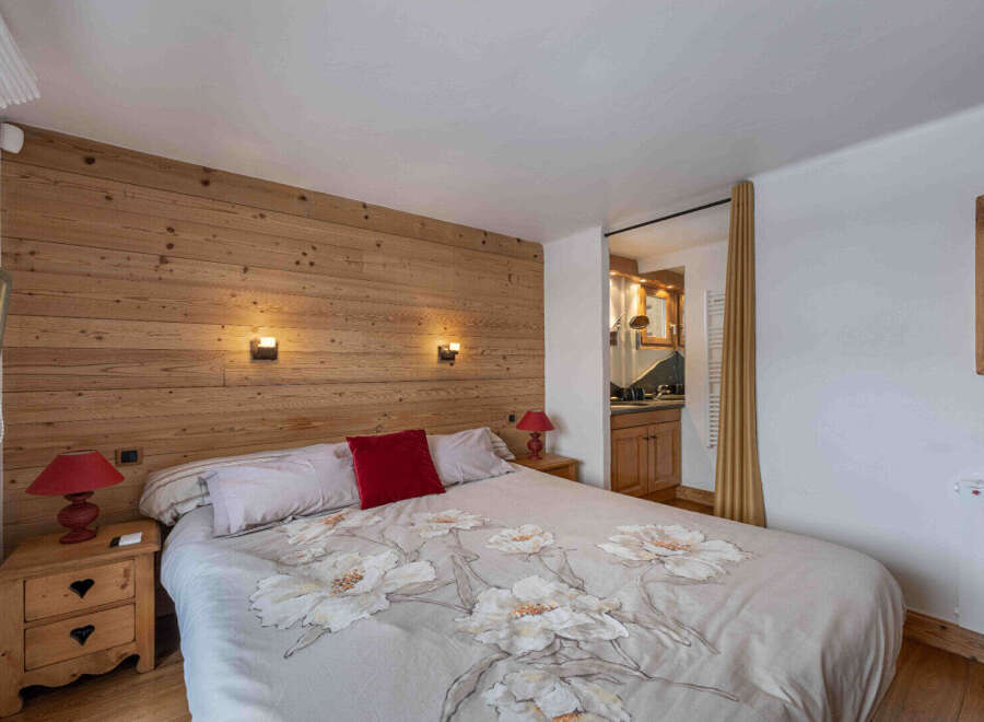 This cozy bedroom features a stunning wooden accent wall, creating a warm and inviting atmosphere.
