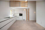 This modern kitchen features sleek white cabinetry and a built-in oven, creating a clean and minimalist aesthetic.