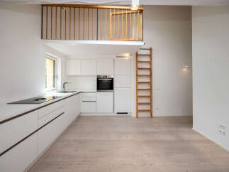 This modern kitchen features sleek white cabinetry and a built-in oven, creating a clean and minimalist aesthetic.