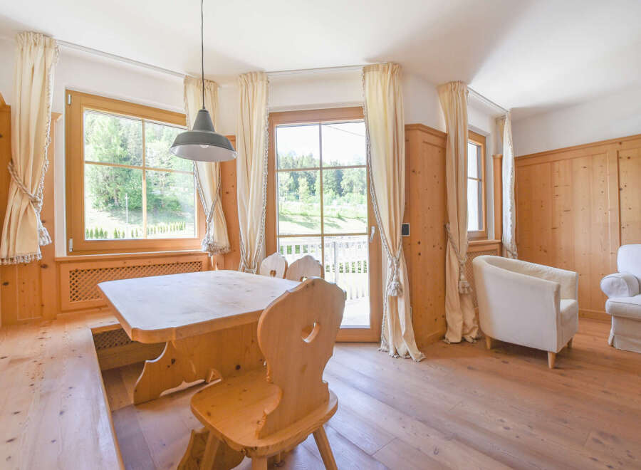 Experience rustic charm in this inviting dining area, featuring a solid wood table and benches perfect for family gatherings.