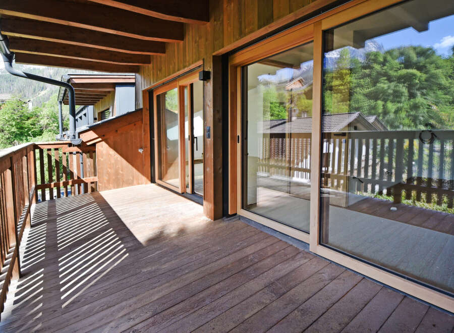 Experience the charm of this wooden balcony, offering a serene outdoor space with stunning mountain views.