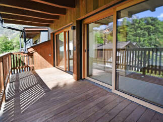 Experience the charm of this wooden balcony, offering a serene outdoor space with stunning mountain views.