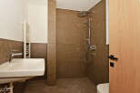 Experience modern comfort in this beautifully appointed bathroom, featuring a sleek sink and a spacious walk-in shower with elegant brown tilework.