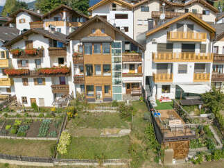 Discover this charming multi-story home featuring multiple balconies adorned with vibrant flowers, perfect for enjoying the scenic surroundings.