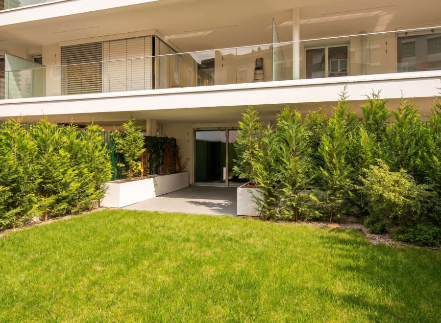 Experience modern living in this stunning property featuring a spacious balcony with glass railings and sleek blinds.
