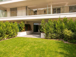 Experience modern living in this stunning property featuring a spacious balcony with glass railings and sleek blinds.