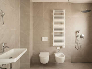 Experience modern luxury in this impeccably designed bathroom, featuring a sleek wall-mounted sink with chrome fixtures and a spacious walk-in shower.