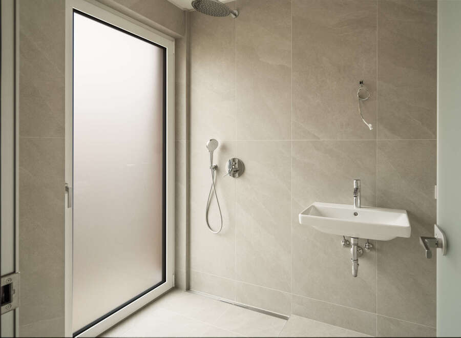 Experience modern comfort in this sleek bathroom, featuring a spacious walk-in shower with a rainfall showerhead and a convenient handheld sprayer.