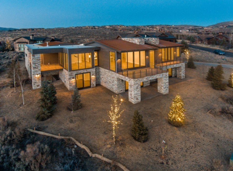 Stunning modern mountain home with expansive windows offering breathtaking views.