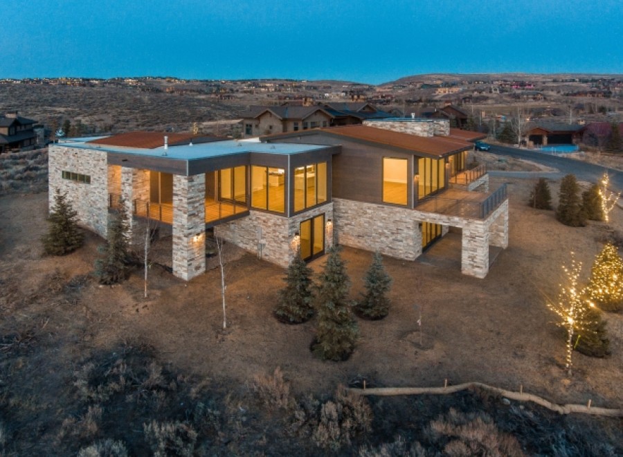 Stunning modern mountain home with expansive windows offering breathtaking views.